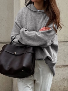 Women's casual grey hooded knitted sweatshirt styled with a dark brown leather tote bag