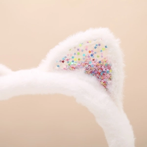 Detailed macro view of white plush cat ears with colorful star sequins inside the ear part