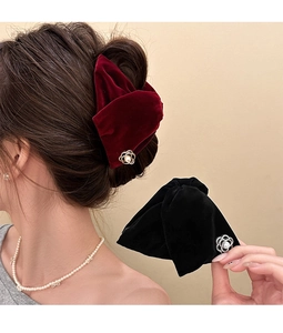 Close-up of velvet floral shark hair claw with camellia pearl detail and model view