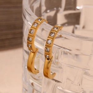 Close-up of 18K gold-plated C-shaped earrings with micro-set square cubic zirconia
