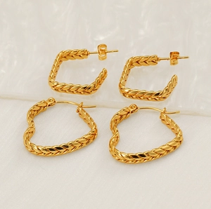 Detailed view of gold wheat grain textured heart hoops and C-shaped stud earrings set
