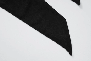 Gros plan sur la texture du tissu en maille noire et les bords nets de la sangle de robe