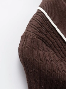 Nahaufnahme von braunem Zopfstrickmuster und weißen Kontrastkragen-Details