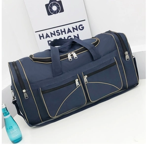 Detail of navy blue Oxford fabric travel bag with zipper compartments and carry straps