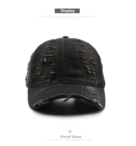 Front view detail of distressed black washed cotton baseball cap with ripped brim edges