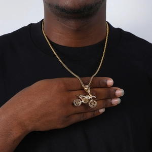 Close-up of gold iced out motorcycle pendant with twisted rope chain on model