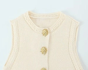 Détail du gilet en maille beige avec boutons dorés décoratifs et col rond élégant