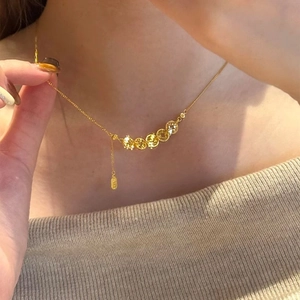 Élégant collier de pièces dorées de style rétro porté sur une femme sous une lumière douce