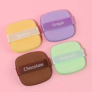 Set of four colorful square makeup puffs in yellow, purple, brown and green colors
