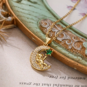 Macro shot of gold-plated crescent moon and bear pendant with green star zircon