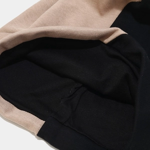 Detail of two-tone ribbed knit fabric showing beige and black contrast and fine stitching