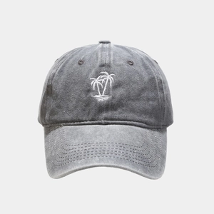 Detail of white palm tree embroidery on washed dark grey vintage baseball cap