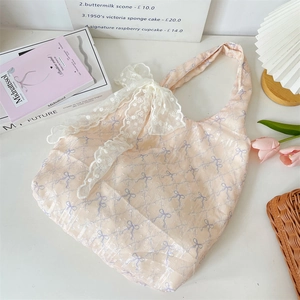 Détail du sac en toile rose avec nœud en dentelle blanche et motifs de nœuds violets