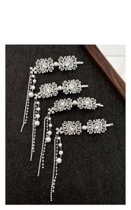 Detailed view of silver flower hairpins with rhinestone tassels and faux pearls