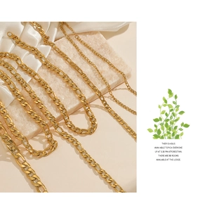 Close-up of three different widths of gold plated Cuban chain necklaces on silk
