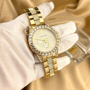 Luxury gold women's watch with full zircon diamonds and three-eye dial on silk backdrop