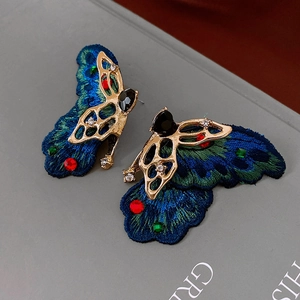 Macro detail of butterfly earrings with colorful embroidery and sparkling rhinestones