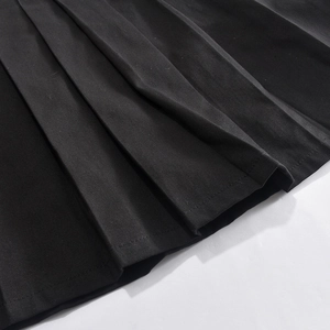 Detail view of the black pleated skirt hem showing high-quality twill fabric texture
