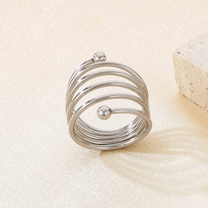 Close-up of polished stainless steel spiral ring with double beads on satin background