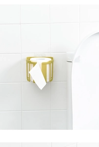 Detail of wall-mounted mustard yellow paper towel holder showing hollow breathable structure