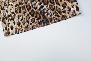 Macro detail of leopard print fabric with shiny sequins and double-needle hem stitching