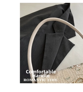 Détail de la poignée en cuir crème et texture tissée sur un petit sac carré