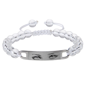 Macro detail of custom eye photo engraved on metal plate with clear beaded bracelet