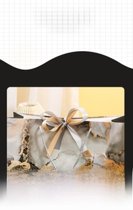 Detail of marble pattern gift bag with champagne ribbon bow and silver woven handle