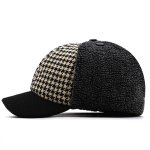 Side view of winter baseball cap featuring black and white houndstooth with ear flaps
