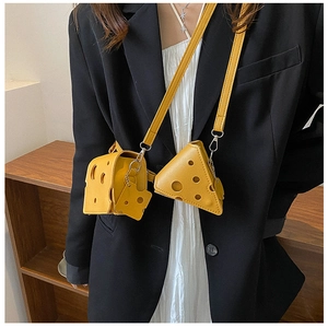 Close-up of cheese shaped yellow PU leather crossbody bag with adjustable strap on model
