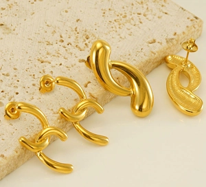 Detailed shot of 18k gold plated geometric earrings on a textured stone surface