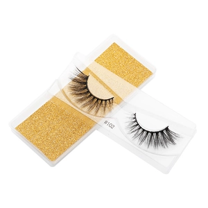 Detail of 3D faux mink lashes model 102 with gold glitter base in clear packaging