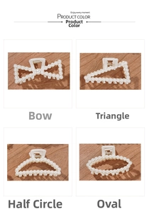 Detail of four pearl hair claws in bow, triangle, semicircle and oval shapes on wood