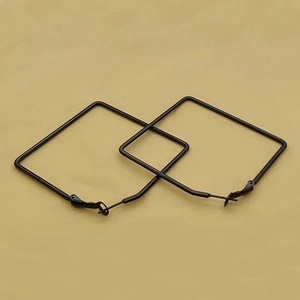 Detail of large black square hoop earrings featuring a matte metallic finish