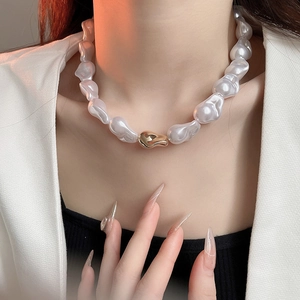 Détail d'un collier en perles baroques avec fermoir doré élégant au style français