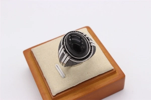 Vue détaillée d'une bague rétro en acier avec pierre ovale noire et motifs texturés