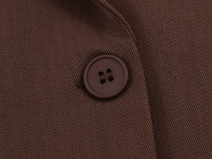 Makroaufnahme von Zwei-Knopf-Verschluss an einem dunkelbraunen Oversize-Twill-Blazer