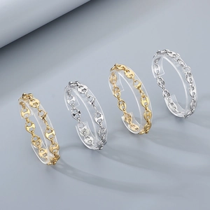 Detail of pig nose chain bracelets in gold and silver finishes on acrylic stands