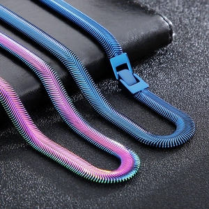 Flat lay of minimalist blue and rainbow titanium flat snake chain necklaces on black background