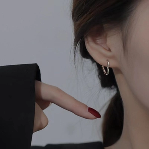 Minimalist silver hollow heart hoop earrings worn by a model in a luxury style