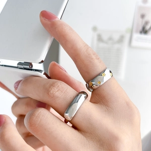 Two-tone stainless steel ring set featuring star motif and minimalist polished band design