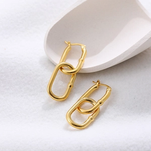 Detail of 18K gold-plated stainless steel double rectangular link earrings on white sand