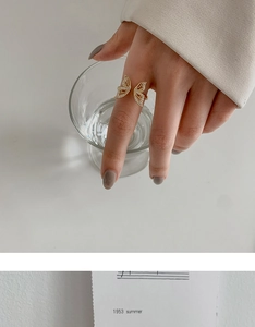 Close-up of golden butterfly open ring with sparkling cubic zirconia on a model's hand