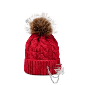 Detailed knit texture of red beanie with silver butterfly pin and metallic chains