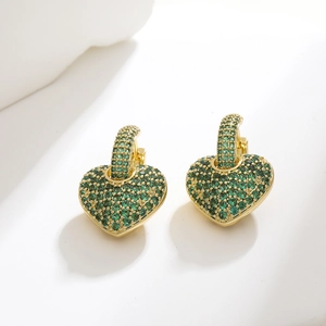 Detail of gold-plated heart hoop earrings encrusted with sparkling green emerald zircons