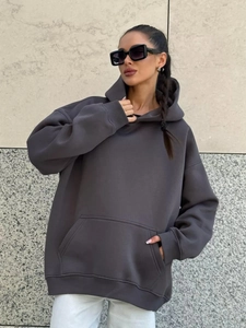 Detail of dark gray oversized hoodie showing premium thick cotton fabric and pocket