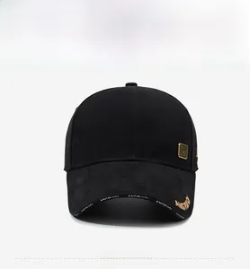 Close-up of black cotton baseball cap with white letter prints and gold embroidery details