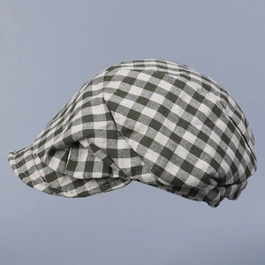 Close-up of dark green and cream checkered linen flat cap showing woven fabric texture