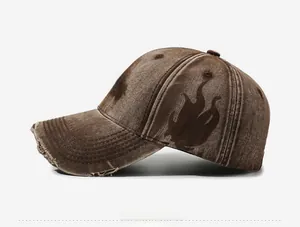 Detail of vintage washed brown baseball cap with flame pattern and distressed brim edge