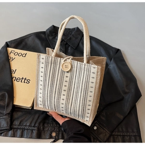 Close-up of striped linen tote bag with cotton rope handle and large button detail